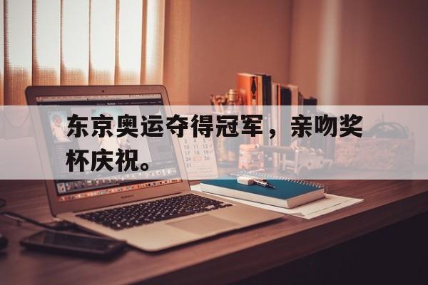 爱游戏app下载-东京奥运夺得冠军，亲吻奖杯庆祝。